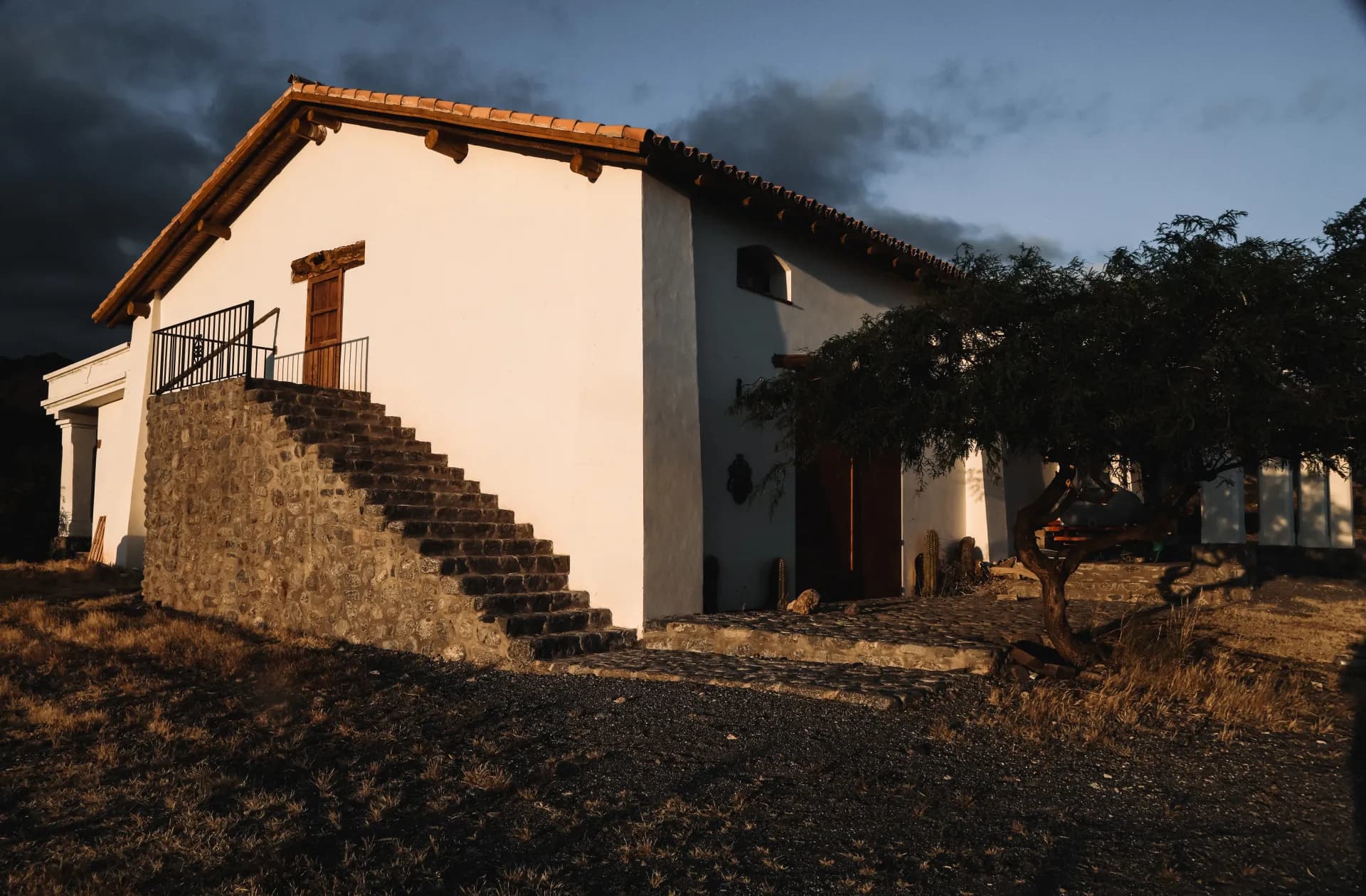 Fachada de la bodega Arca Yaco al atardecer con escalera de piedra